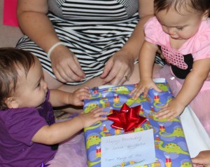 The twins teaming up to open their birthday present.